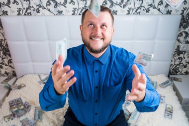 Mavi gömlekli sakallı iyi bir adam, dolarlara sevinir, onları kusar ve sayar. Piyango kazanın