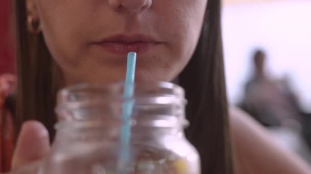 Een vrouw in een café, drinkt een smoothie, Leafs door het menu, leest berichten op de telefoon en schrijft het antwoord. Close-up — Stockvideo