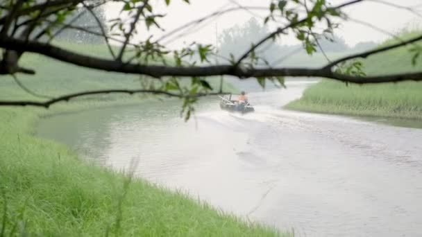 Motorlu teknedeki bir balıkçı kıyıdan geliyor. kıyıdan görünüm — Stok video