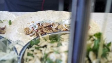 Shawarma hazırlama işlemi, aşçı malzemeyi koyar. Yakın çekim