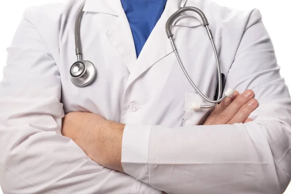 Un médico vestido de blanco está de pie con las manos cruzadas sobre el pecho, un estetoscopio colgando de su cuello. De cerca. —  Fotos de Stock