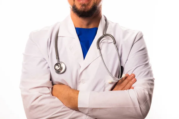 Een arts in witte kleren staat met zijn handen gevouwen over zijn borst, een stethoscoop opknoping op zijn nek. Close-up — Stockfoto