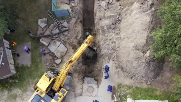 Escavatore e lavoratori scavare una fossa per tubi — Video Stock