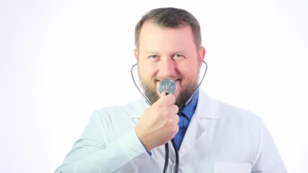 Niza gordito médico con una barba en un abrigo blanco sobre un fondo blanco aislado — Vídeo de stock