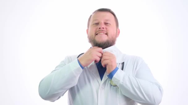 Bom médico gordinho com uma barba em um casaco branco em um fundo isolado branco — Vídeo de Stock