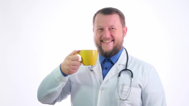 Netter molliger Arzt mit Bart in weißem Mantel auf weißem isoliertem Hintergrund — Stockvideo