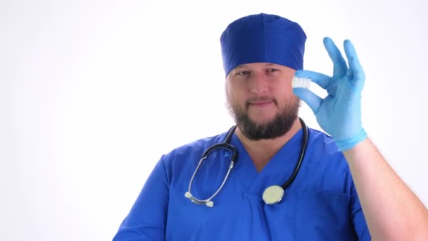 Niza gordito médico con una barba en un abrigo azul y sombrero azul — Vídeo de stock