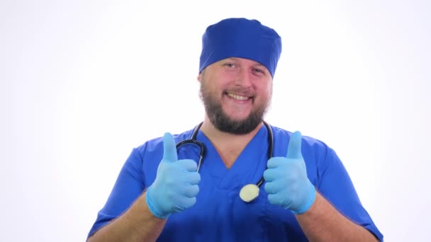 Nice Chubby Doctor con un estetoscopio en ropa azul sobre un fondo blanco aislado . — Vídeo de stock