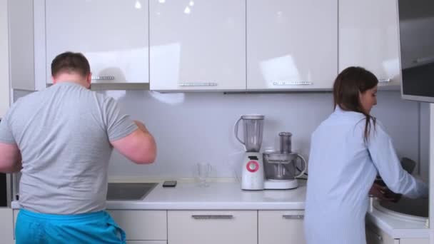 Pufók férfi és nő táncol és énekel a konyhában főzés közben otthon, a koncepció egy boldog szórakoztató család — Stock videók