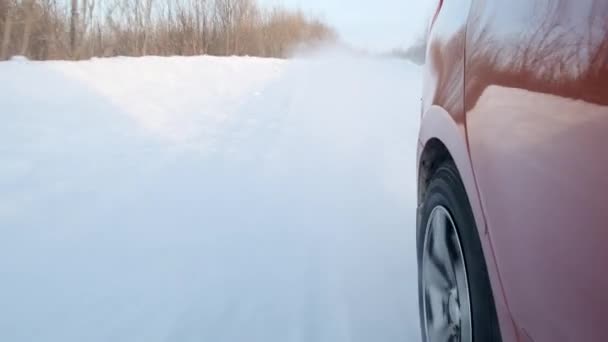 Вид заднего колеса движущегося седана зимой — стоковое видео