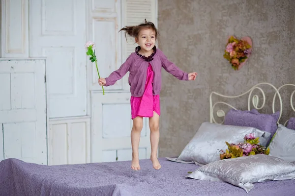 Niña Con Flores Saltando Cama — Foto de Stock