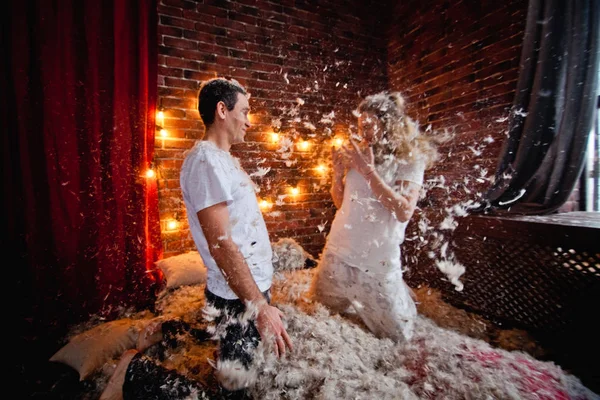 boy and girl comic pillow fight with flying feathers