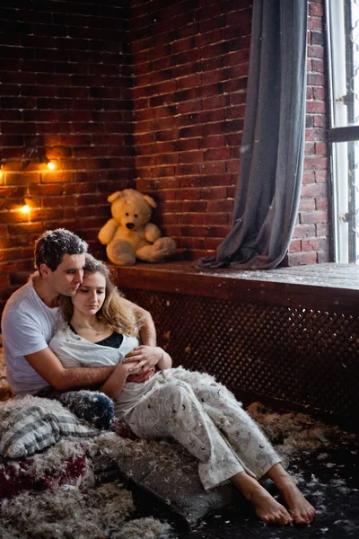 Loving couple man and woman on bed in feathers