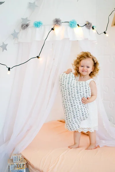 Ένα Κοριτσάκι Παίζει Μια Λευκή Ηλιόλουστη Κρεβατοκάμαρα Ένα Παιδί Παιχνίδια — Φωτογραφία Αρχείου