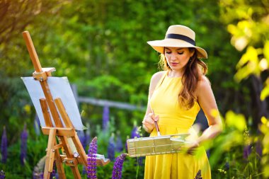 Sarı elbiseli ve şapkalı bir kız sanatçı açık havada lup tarlasını boyuyor. Tuvalle, yağlı boyayla, paletle ve sanatçı aletleriyle. Bir fırça tutar ve çizer..