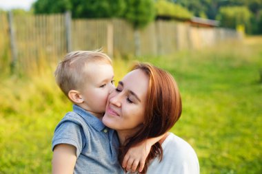 Birlikte hayatın tadını çıkarıyoruz. Mutlu anne ve oğul güneşli bir yaz gününde dışarıda eğleniyorlar. Anne ve oğul birlikte eğleniyorlar. Anneler Günü.