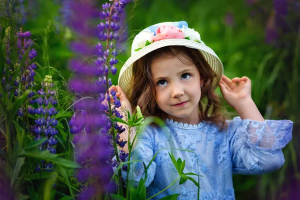 Hermosa Niña Vestido Sombrero Campo Altramuces Niña Sonríe Sostiene Sombrero — Foto de Stock