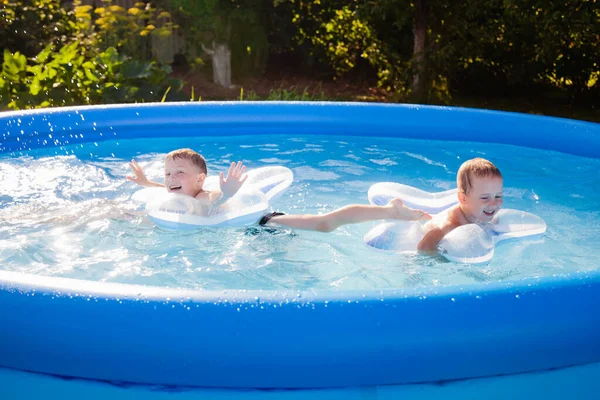 Dois Meninos Estão Nadando Alegremente Piscina Círculos Infláveis Forma Uma — Fotografia de Stock