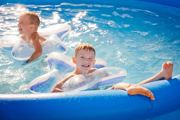 Dois Meninos Estão Nadando Alegremente Piscina Círculos Infláveis Forma Uma — Fotografia de Stock