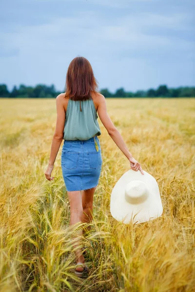 Dívka Hnědými Vlasy Prochází Pšeničným Polem Ruce Drží Klobouk Pohled — Stock fotografie