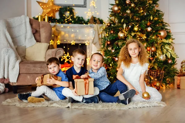 Evdeki Noel ağacının altında bir grup çocuk. Süslü kostümlü kızlar ve erkekler kış tatilini kutluyorlar. Çocuklar şöminenin yanındaki hediyeleri açın..