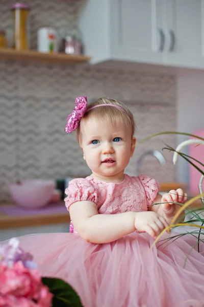 Ребенок Праздничном Розовом Платье Кухне Цветами Гортензии Сидит Улыбается — стоковое фото