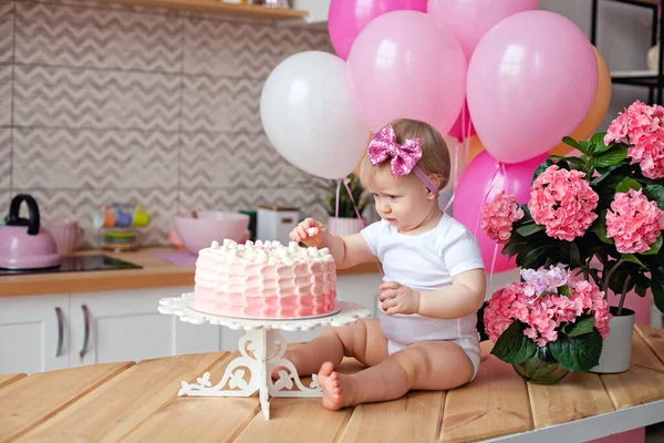 桌上有一个可爱的小女孩 她带着生日蛋糕和粉色气球 庆祝儿童的第一年 — 图库照片