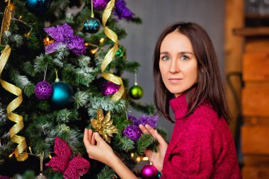 Bir Noel ağacını süsleyen uzun saçlı çekici bir bayanın portresini yakından çek.