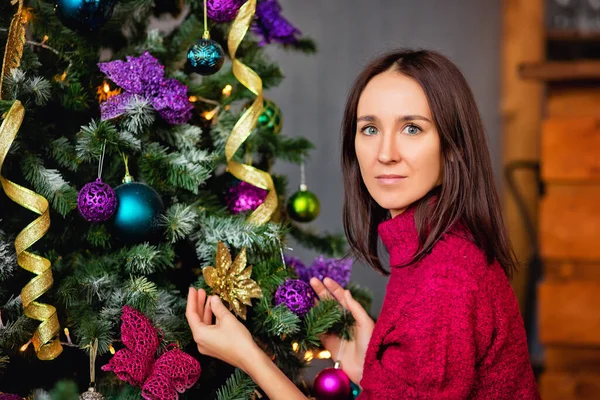 Bir Noel ağacını süsleyen uzun saçlı çekici bir bayanın portresini yakından çek.