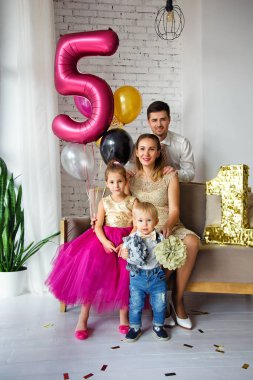 İki çocuklu bir ailenin portresi. Doğum günü partisi. Aile, kızlarının ve oğullarının doğum gününü kutlar..