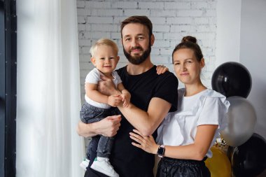 Mutlu bir anne ve babanın portresi. Oğullarıyla birlikte bir tatilde aile fotoğrafı için poz veriyorlar. Kameraya bakarken sevimli oğlana sarıl.