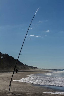 Bir olta kamışı bir plaj sıcak bir yaz gününde sıkışmış. Bay of Plenty içinde Yeni Zelanda fotoğrafı