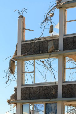 Yıkılan binanın son ayakta duvarı. Ufalanmış beton, bükümlü takviye teli ve kırık camlar