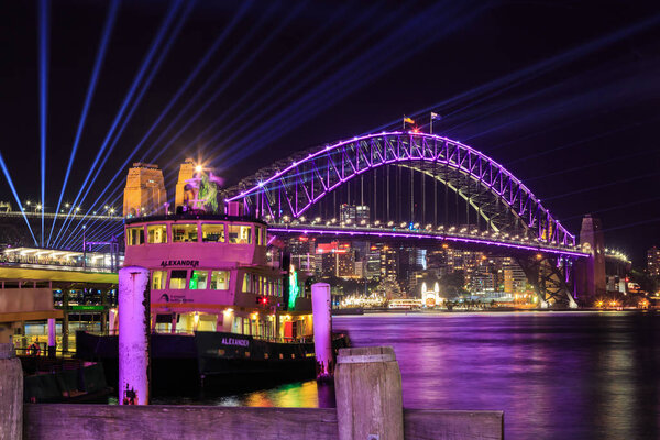 Sydney Harbour Bridge with colored lighting and searchlight beams during the "Vivid Sydney" festival. Sydney, Australia, May 26 2019 