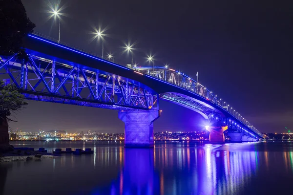 Auckland Harbour köprüsü, Auckland, Yeni Zelanda, köprünün kuzey ucundaki Stokes Point'ten gece görüldü. Renkli aydınlatma Matariki için bir ekran, Maori Yeni Yıl 