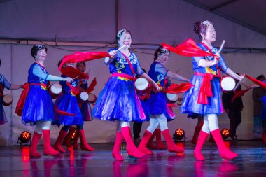 Çinli kadınlar parlak kırmızı eşarplar ve bel davullarıyla sahnede dans ediyorlar. Auckland, Yeni Zelanda 'da, 14 Eylül 2019' da Ay 'da (sonbahar ortasında) festival kutlamaları çekilmiştir. 