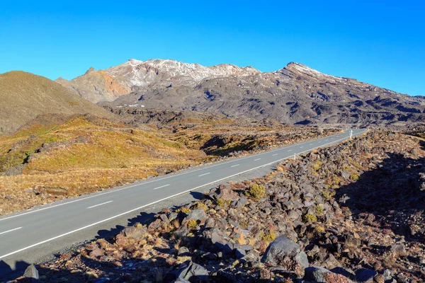 The road up Mount Ruapehu, New Zealand, leading to Iwikau Ski Village. The first snow of the season is appearing on the rocky slopes