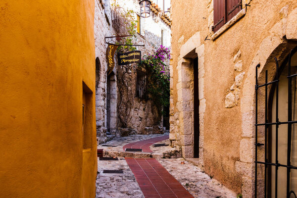 Narrow alley and old stone houses in Eze village in France.