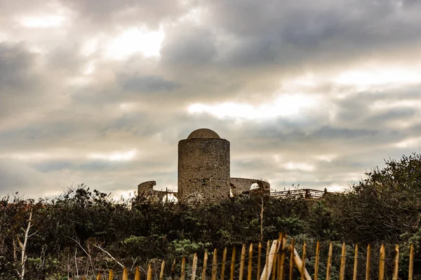 Ruins of an ancient stone mill built on the cliff top at Bonifacio in Corsica at sunrise.