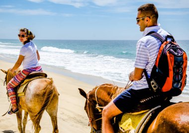 Cabo San Lucas, Mexico - 2019. Young couple horseback riding on the beach in Cabo san Lucas, Baja California. clipart