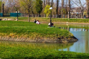 Targoviste, Romanya - 2019. Bir grup insan çimenlerin üzerinde 