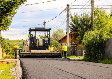 Targoviste, Romanya - 2019. Asfalt paver mach çalışan işçiler