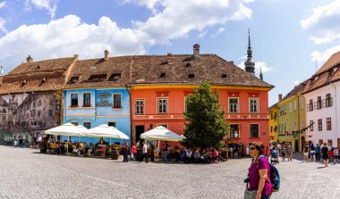 Sighisoara, Romanya - 2019. İnsanlar öğle yemeği yiyor ve dolaşıyor