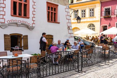 Sighisoara, Romanya - 2019. İnsanlar öğle yemeği yiyor ve dolaşıyor
