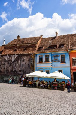 Sighisoara, Romanya - 2019. İnsanlar öğle yemeği yiyor ve dolaşıyor
