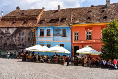 Sighisoara, Romanya - 2019. İnsanlar öğle yemeği yiyor ve dolaşıyor
