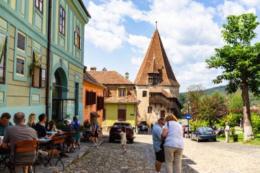 Sighisoara, Romanya - 2019. İnsanlar öğle yemeği yiyor ve dolaşıyor