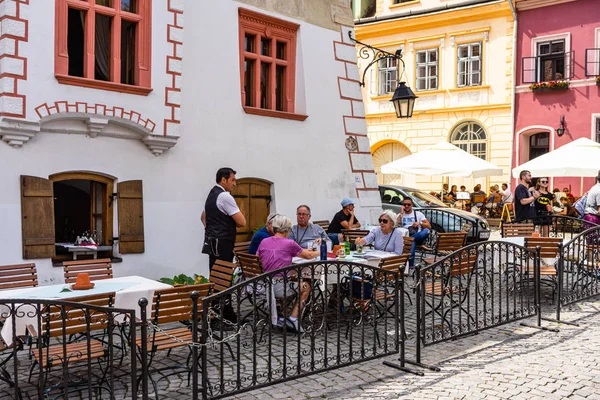 Sighisoara, Romanya - 2019. İnsanlar öğle yemeği yiyor ve dolaşıyor