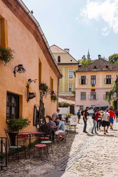 Sighisoara, Romanya - 2019. İnsanlar öğle yemeği yiyor ve dolaşıyor