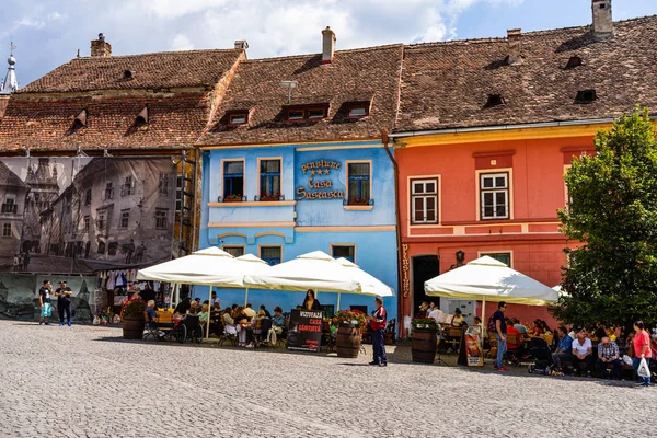 Sighisoara, Romanya - 2019. İnsanlar öğle yemeği yiyor ve dolaşıyor